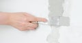 Female hand repairs wall