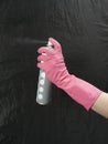 Female hand in a rubber glove with an aerosol can. prevention of coronovirus infection