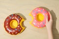 Female hand and rubber rings on sand background