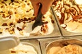 Female hand with scoop takes ice cream from the fridge and serving in waffle cone. Woman taking scoop of tasty ice cream.