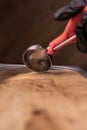 Female hand scooping chocolate ice cream from container, close up