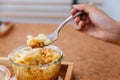 Female hand is scooping Macaroni Cheese Baked with meat sauce in glass bowl Royalty Free Stock Photo