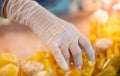 Female hand seller wearing surgical glove and selling the fresh pineapple for hygience to buyer at the local market