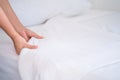 Female Hand set up white bed sheet in bedroom or maid hands making bed in a hotel room Royalty Free Stock Photo