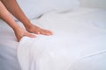 Female Hand set up white bed sheet in bedroom or maid hands making bed in a hotel room Royalty Free Stock Photo