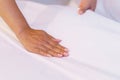 Female Hand set up white bed sheet in bedroom or maid hands making bed in a hotel room Royalty Free Stock Photo