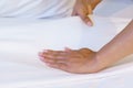 Female Hand set up white bed sheet in bedroom or maid hands making bed in a hotel room Royalty Free Stock Photo