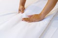 Female Hand set up white bed sheet in bedroom or maid hands making bed in a hotel room Royalty Free Stock Photo