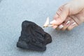 Female hand sets fire to coal, close-up