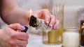 Female hand sets fire to incense on a copper bowl. Aroma therapy, to relax after a hard day. Smells for concentration