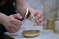 Female hand sets fire to incense on a copper bowl. Aroma therapy, to relax after a hard day. Smells for concentration