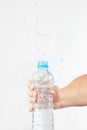 Female hand shaking small bottle of fresh water with splash Royalty Free Stock Photo