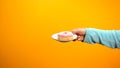 Female hand showing sweet donut, inviting customers to confectionary store