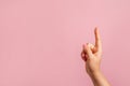 Female hand shows the forefinger up on pink background, copy space Royalty Free Stock Photo