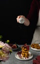 Female hand sieving sugar powder on breakfast waffles, fresh figues