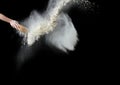 Female hand sifts white wheat flour through a round wooden sieve on a black background Royalty Free Stock Photo