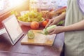 Female hand slicing green vegetable, prepare ingredients for cooking follow cooking online video clip on website via tablet.