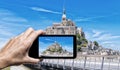 Female hand with smartphone taking a picture of Mont Saint Miche