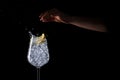 Female hand splashing lemon into the iced water