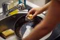 Female hand with sponge washing dish in the kitchen