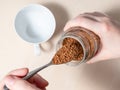 Female hand spooning up instant coffee from jar Royalty Free Stock Photo