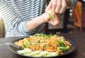 Female hand squeezing lime on Pad Thai Royalty Free Stock Photo