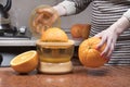 Female hand squeezing orange juice. Closeup on womenÃ¢â¬â¢s hand making orange juice. Juicing oranges