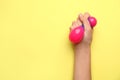 Female hand squeezing stress ball on color background Royalty Free Stock Photo