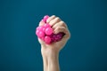 Female hand squeezing stress ball on color background Royalty Free Stock Photo