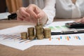 Female hand stacking euro coins into columns above business diagram