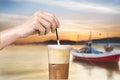 Female hand stirring a straw on a greek cold coffee, freddo cappuccino, outdoors Royalty Free Stock Photo