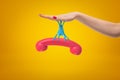 Female hand stuck to pink retro telephone receiver with sticky slime on yellow background. Royalty Free Stock Photo