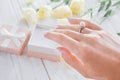 Female hand surrounded with flowers wearing a ring with pearl. Proposal. Royalty Free Stock Photo