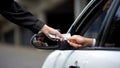 Female hand taking dollars from driver, parking payment, car rent service, order