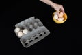 Female hand taking one egg from yellow bowl on black background Royalty Free Stock Photo