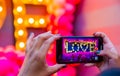 Female Hand taking a photo on her mobile phone of the word Love Royalty Free Stock Photo