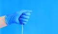 Female hand in a blue latex medical glove holds a tampon Royalty Free Stock Photo