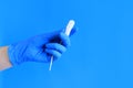 Female hand in a blue latex medical glove holds a tampon Royalty Free Stock Photo