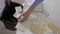 Female Hand Throws Medicine Pills Into Trash Bin. Medication Healthcare Concept
