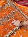 Female hand touches indian fabric of orange color Royalty Free Stock Photo