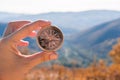 Female hand of traveler, hiker with compass on background autumn forest landscape with mountains on the horizon in