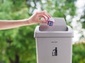 female hand trowing a paper into a garbage bin on bokeh background. cleaning concept. Royalty Free Stock Photo