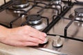Female hand turn on gas stove. Royalty Free Stock Photo