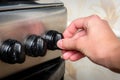 Female hand turn on gas stove in kitchen Royalty Free Stock Photo