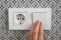 Female hand turn off light switch on plastic switched double socket Royalty Free Stock Photo