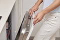 female hand turning on dishwasher machine in kitchen Royalty Free Stock Photo