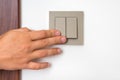 Female hand is turning on or off interior light switch Royalty Free Stock Photo