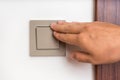 Female hand is turning on or off interior light switch Royalty Free Stock Photo