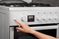 Female hand turning on white kitchen gas stove Royalty Free Stock Photo