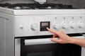 Female hand turning on white kitchen gas stove Royalty Free Stock Photo